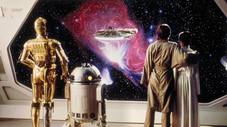 Luke, Leia, R2-D2 et C-3PO regardent le Faucon Millenium s'envoler à la fin de 