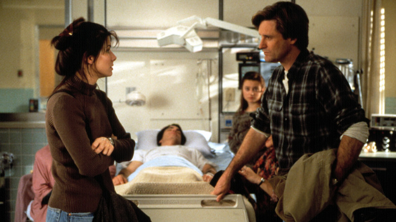 Lucy et Jack discutent dans la chambre d'hôpital de Peter dans Pendant que tu dormais