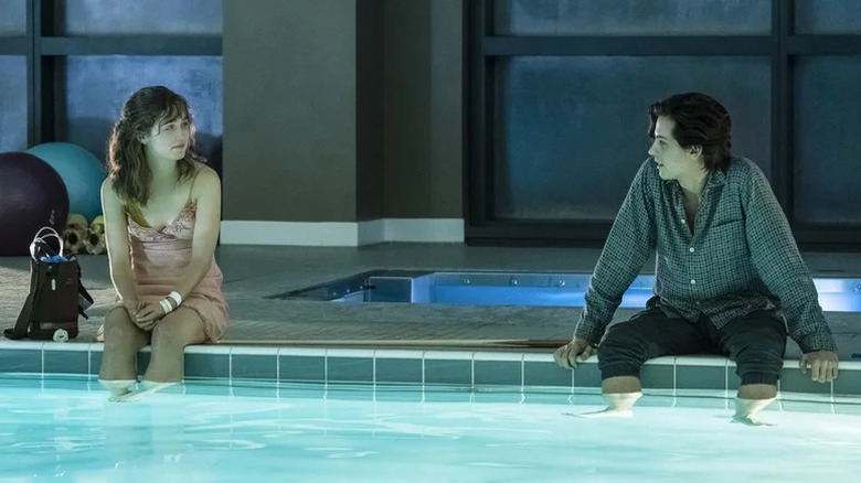 Stella et Will assis au bord de la piscine dans Five Feet Apart