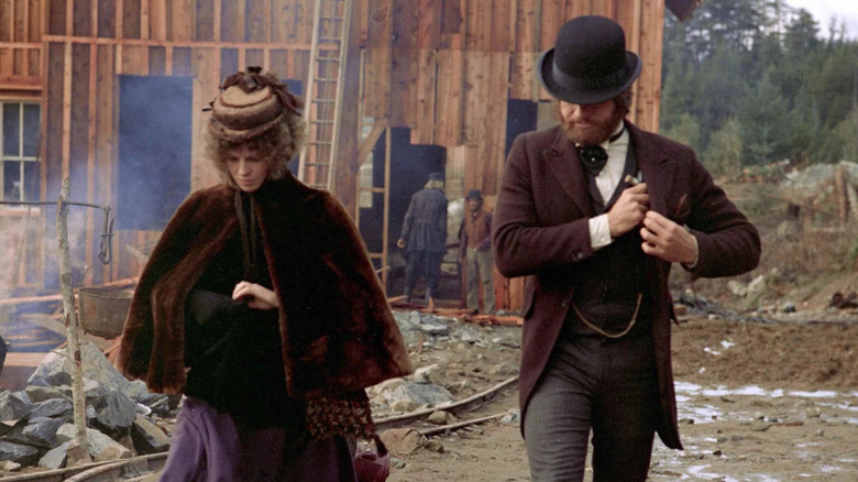 John McCabe et Mme Miller se promenant dans un bâtiment en ruine 