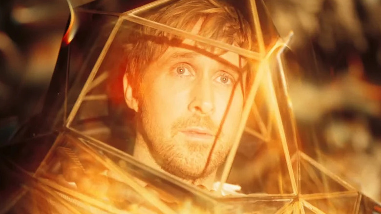Ryland Grace dans une combinaison spatiale, baignée d'une lueur orange 