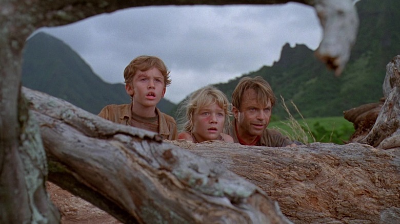 Grant, Lex et Tim se cachent derrière une bûche