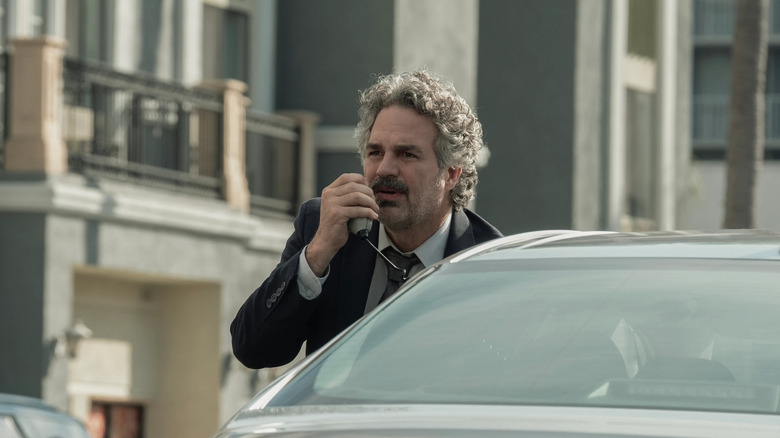 Lou parle dans une radio dans sa voiture dans Crime 101