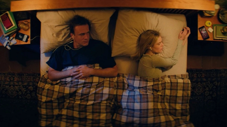 Dan et Lisa au lit avec des écouteurs dans Over Your Dead Body