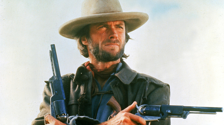Josey Wales croise les bras avec des armes à la main