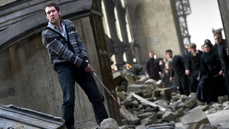 Neville tenant une épée dans les décombres