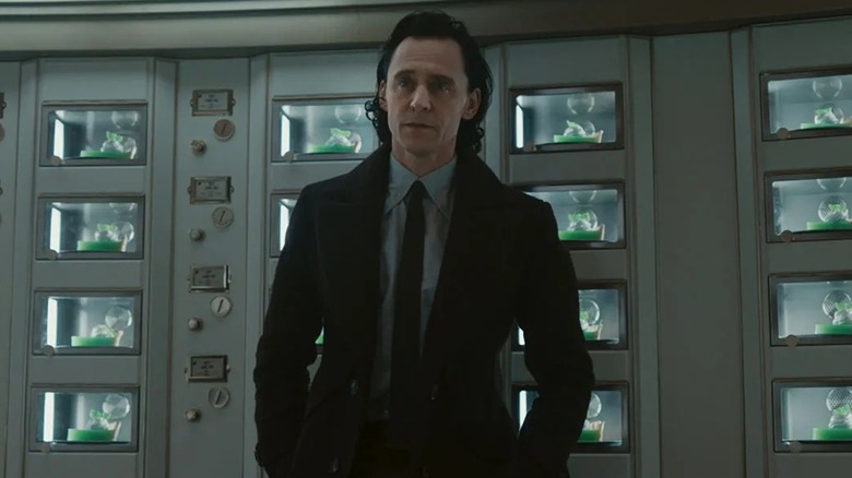 Loki debout devant plusieurs présentoirs à tartes 