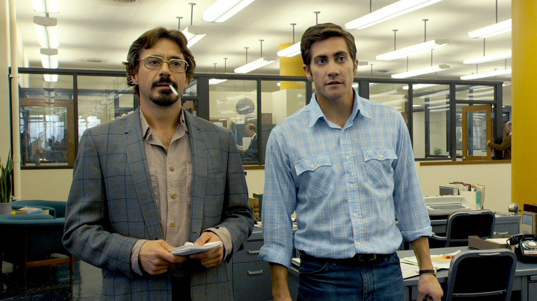 Robert Graysmith et Paul Avery debout dans le bureau d'un journal dans Zodiac (2007)