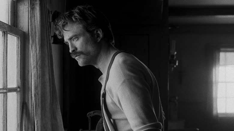 Ephraim Winslow regardant par la fenêtre du phare dans The Lighthouse (2019)