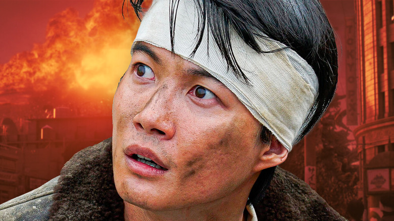 Un Kōichi bandé se tient devant une ville détruite