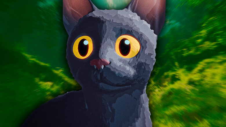 Un chat gris regardant devant un fond vert