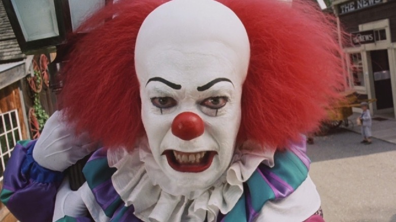 Tim Curry dans le rôle de Pennywise grondant contre une caméra de rue