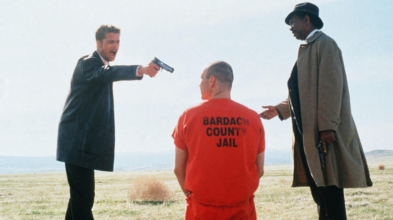 Mills pointe son arme sur John Doe pendant que Somerset regarde entrer 
