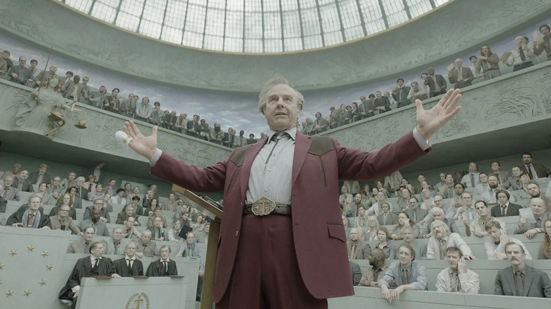Digger Rockwell s'adressant au Parlement européen dans Digger (2026)