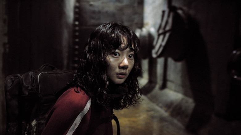 Park Hyun-seo essayant de voir si le monstre est toujours là dans The Host (2006)