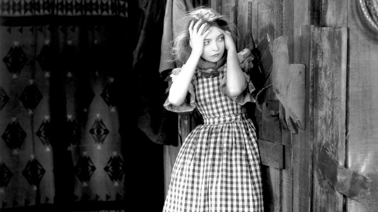 Une Letty tourmentée se tenant la tête dans The Wind (1928)