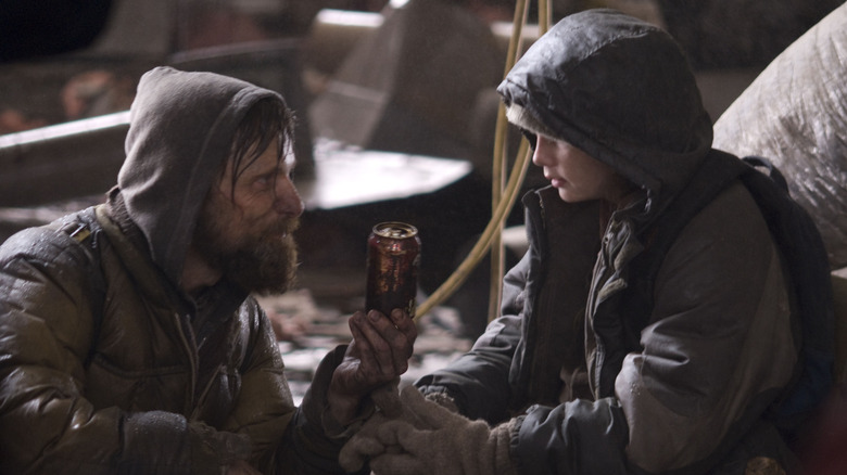 père donnant une canette de soda à son fils dans The Road (2009)