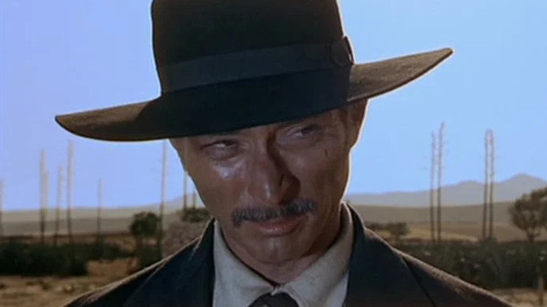 Le colonel Douglas Mortimer avec un chapeau noir et une moustache dans Pour quelques dollars plus
